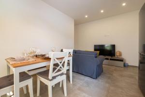 a living room with a table and a blue couch at La casa di Guido in San Giovanni in Marignano
