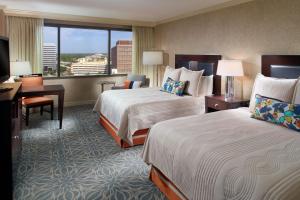 a hotel room with two beds and a desk and a window at Marriott Jacksonville Downtown in Jacksonville