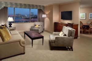 Marriott Jacksonville Downtown في جاكسونفيل: غرفة معيشة مع كراسي وتلفزيون في غرفة الفندق