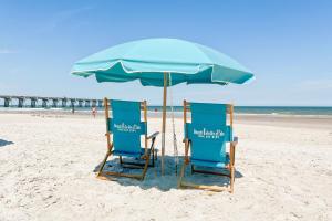 2 sedie sotto un ombrellone in spiaggia di Marriott Jacksonville Downtown a Jacksonville
