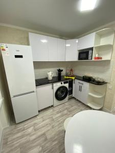 eine Küche mit einem Kühlschrank und einer Waschmaschine in der Unterkunft Апартаменты Балхаш (Набережная) in Balqasch