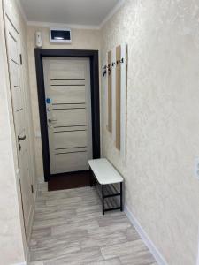 un pasillo con una puerta y un banco al lado en Апартаменты Балхаш (Набережная), en Baljash