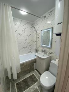 ein Badezimmer mit einem WC, einem Waschbecken und einer Badewanne in der Unterkunft Апартаменты Балхаш (Набережная) in Balqasch
