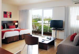 ブエノスアイレスにあるPalermo Suites Buenos Aires Hotel & Apartmentsのベッド2台とテレビがあるホテルの部屋