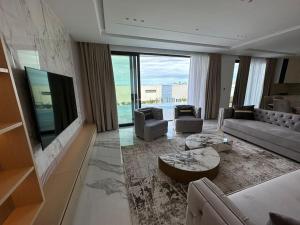 a living room with a couch and a tv at Palmera Gold Vila in Sarandë