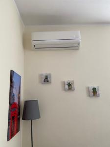 a white air conditioner on a wall next to a lamp at Saba's House in Ghizzano