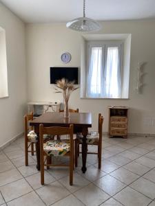 een eetkamer met een tafel en stoelen en een tv bij Saba's House in Ghizzano