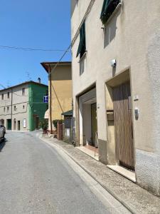 een lege straat naast een gebouw met een deur bij Saba's House in Ghizzano