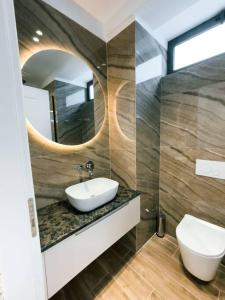 a bathroom with a sink and a mirror at Palmera Gold Vila in Sarandë