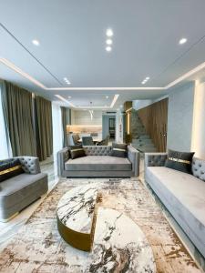 a living room with couches and a table in a room at Palmera Gold Vila in Sarandë