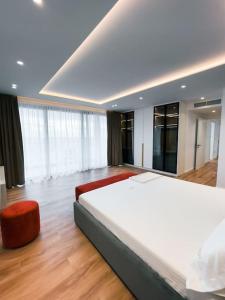 a bedroom with a large bed and a red chair at Palmera Gold Vila in Sarandë +12 photos