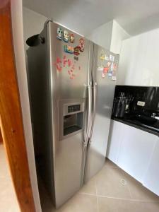 - une cuisine avec un réfrigérateur en acier inoxydable et des aimants dans l'établissement Beautiful apartment in Envigado, à Envigado