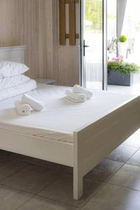 Una cama blanca grande con toallas blancas. en Lotus & Spa, en Solotvyno