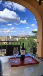 una botella de vino sentada en una mesa con dos copas en Terrazza Del Salento, en Santa Cesarea Terme