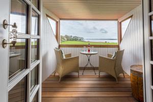 a screened in porch with a table and chairs at Jungshoved Præstegård B&B in Præstø