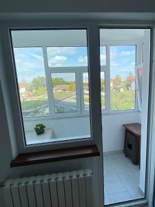 three windows in a room with a radiator and a view at Apartament in Mangalia in Mangalia