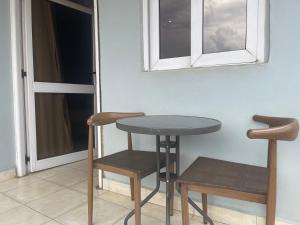 uma mesa e duas cadeiras num quarto com uma janela em Bukandula Hotel em Kampala