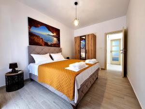 a bedroom with a large bed with a orange bedspread at Apartmani Hortenzija in Budva