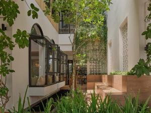 a building with a courtyard with trees and plants at The Motifs Eco Hotel - SHA Extra Plus in Chanthaburi
