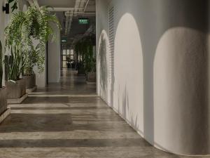 尖竹汶的住宿－The Motifs Eco Hotel - SHA Extra Plus，墙上挂着植物的办公室里空的走廊
