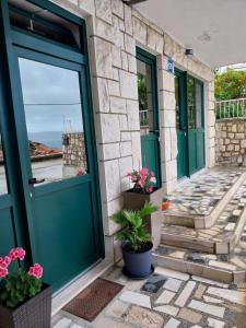 a front door of a house with green doors and plants at Sobe Kraft 2 in Živogošće