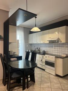 a kitchen with a table and chairs and a kitchen with white appliances at anastasis house in Athens +9 photos