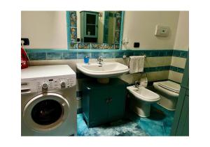 La salle de bains est pourvue d'un lavabo, d'un lave-linge et de toilettes. dans l'établissement Villa Ortensia, à Brindisi