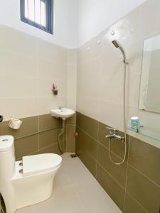 een badkamer met een toilet, een wastafel en een douche bij HOMESTAY HƯƠNG in Vung Tau