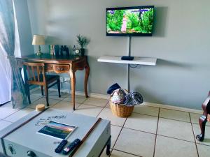 a living room with a table and a tv on the wall at ikhay'olwandle in East London