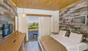 a bedroom with a bed and a tv and a balcony at Alacati VillaRenk in Alacati