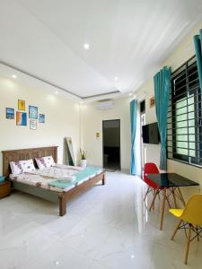 een slaapkamer met een bed en een tafel en stoelen bij HOMESTAY HƯƠNG in Vung Tau
