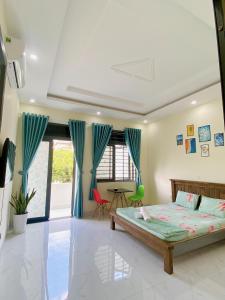 1 dormitorio con 1 cama y cortinas azules en HOMESTAY HƯƠNG, en Vung Tau
