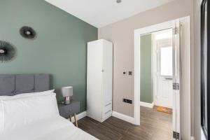 1 dormitorio con cama blanca y espejo en (New) Beautiful Brighton Home, Beach 5min Walk, en Brighton & Hove