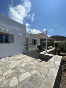 a patio of a white house with a table at Villa Anneza Nikola in Angairiá