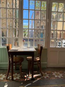 a table and chairs in a room with windows at LA CASA DINA in Banyuls-sur-Mer