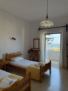 a bedroom with two beds and a view of the ocean at Aeolos Apartments Kolymbari in Kolymvari