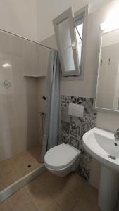 a bathroom with a white toilet and a sink at Marianos Apartments in Antiparos