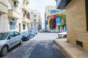Spacious studio apartment Sliema في سليمة: شارع المدينة فيه سيارات تقف على الشارع
