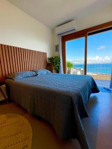 a bedroom with a bed with a view of the ocean at Studio da fonte/Vista mar in Salvador