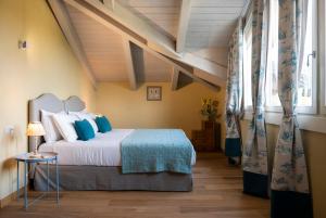 a bedroom with a large bed with blue pillows at Casa San Grato in Monteu Roero