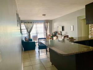 a kitchen with a counter and a living room at ikhay'olwandle in East London