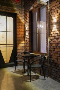 a table and chairs in a room with a brick wall at Hotel and Hostel Ticiani 15 in Kutaisi