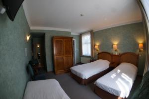 een hotelkamer met 2 bedden en een raam bij Hotel La Porte de France in Bouillon
