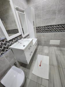 a bathroom with a white toilet and a sink at MARINA APPART Hôtel in Dakar