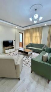 a living room with two couches and a tv at KUDÜS APART in Bostancı