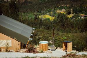 a building with a green roof next to a hill at Quinta dos Corgos in Tábua