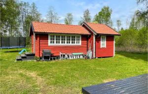 a small red house with a picnic table in a yard at Amazing Home In Gyttorp With Wifi And 3 Bedrooms in Gyttorp