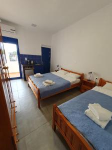 a bedroom with two beds and a kitchen at Babis & Popi Rooms and Studios in Frangokastello