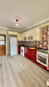 a kitchen with red cabinets and a white refrigerator at KUDÜS APART in Bostancı