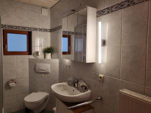 a bathroom with a sink and a toilet and a mirror at Ferienwohnung Seelboomler in Sankt Peter-Ording +38 photos